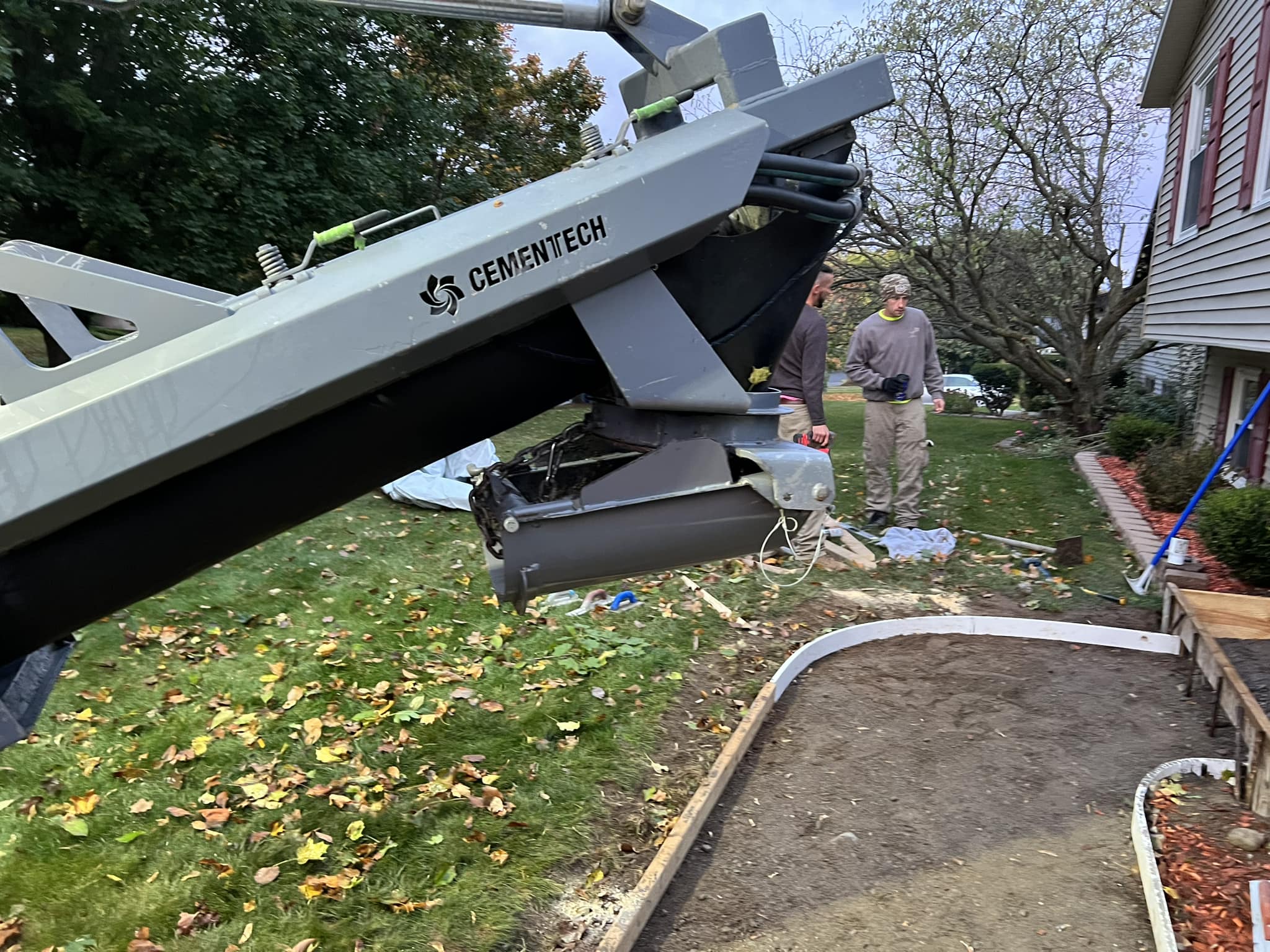 Cementech concrete chute positioned over curved sidewalk form during pour