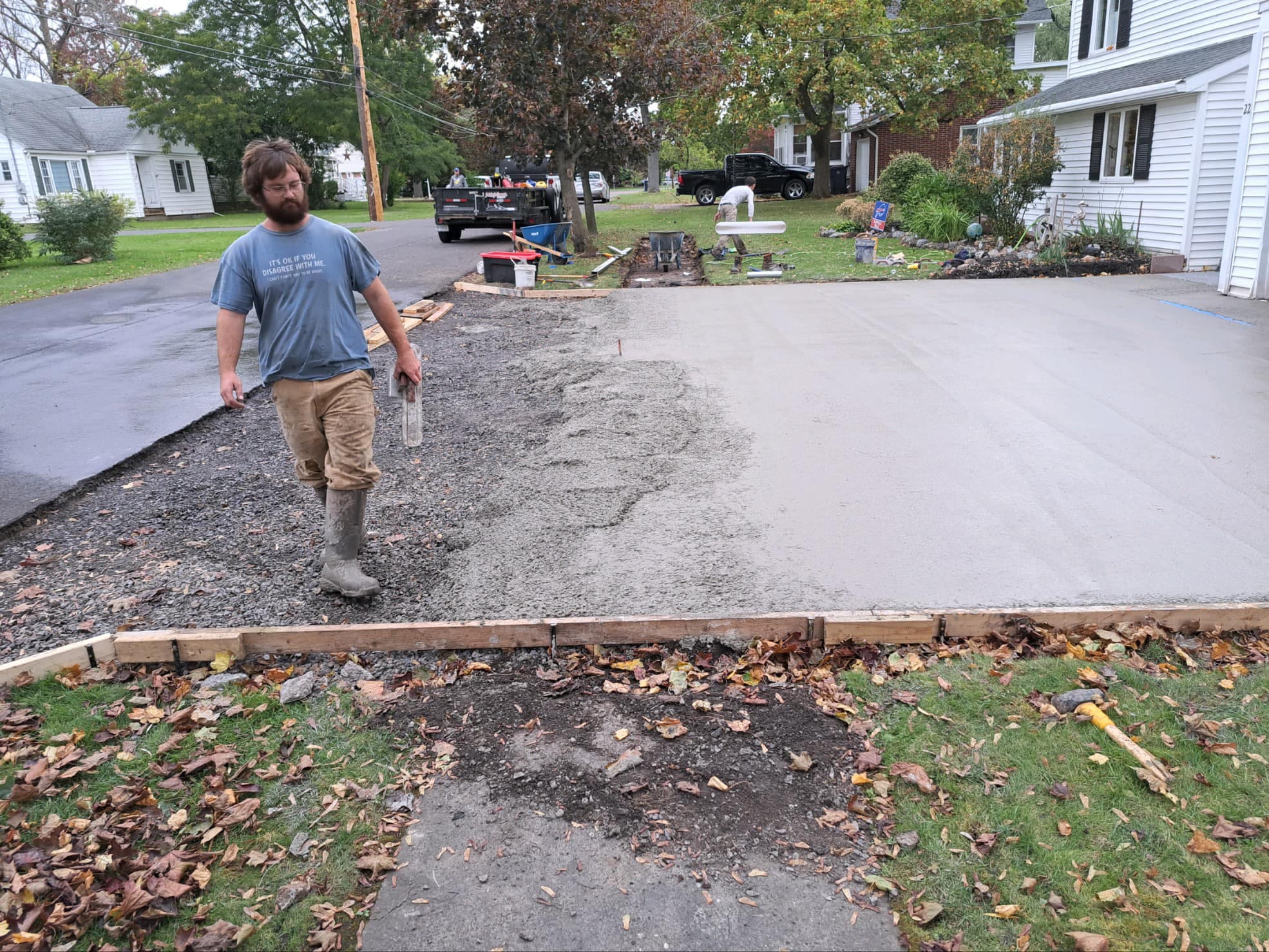 Worker standing on gravel base prepared for concrete driveway installation