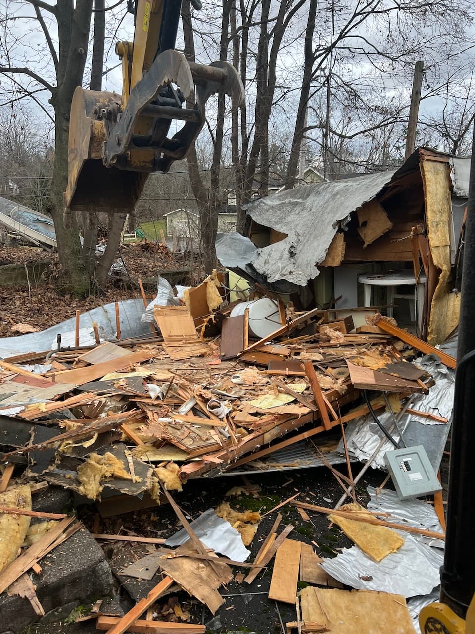 Excavator removing demolished building materials and debris